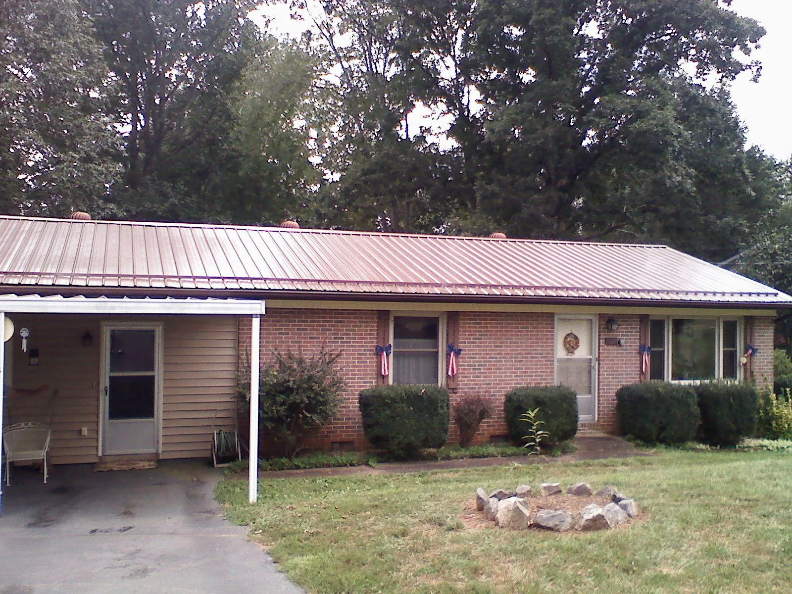 Bronze metal roof and carport on a brick ranch home — Roof Repair work by our crew in Brinkhaven